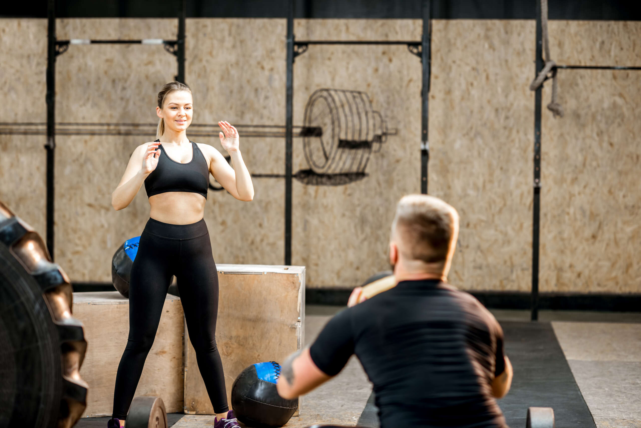 male personal fitness trainer with female gym member